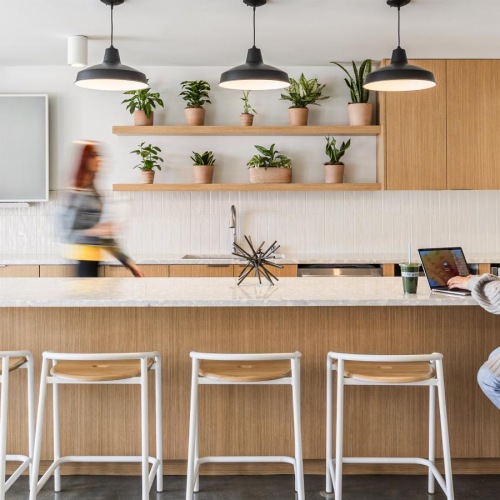 Enjoy our resident-only features a person sitting at a table with a laptop and a person standing behind the counter