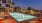 a pool with a deck and buildings in the background